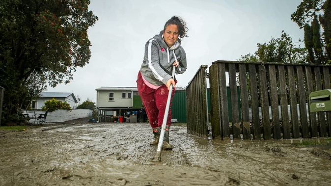 Wairoa resident Libby Young cleaning up her flooded property. Photo / Paul Taylor