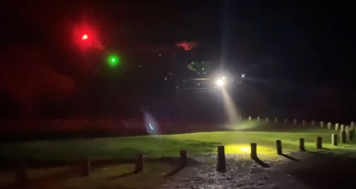 The police Eagle helicopter takes off from Whatipū car park during the search for a missing party of students tramping in the area. Photo / Huia Volunteer Fire Brigade