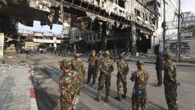 Cambodian military personnel stand guard near a ruined building at the scene of a massive fire at a Cambodian hotel casino in Poipet, west of Phnom Penh, Cambodia. Photo / AP