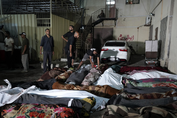 Palestinians check the bodies of their relatives killed in an Israeli bombardment of UNRWA school at Nusseirat refugee camp, in front of the morgue of al-Aqsa Martyrs hospital in Deir al-Balah, central Gaza Strip, early Thursday, June 6, 2024. (AP Photo/Abdel Kareem Hana)