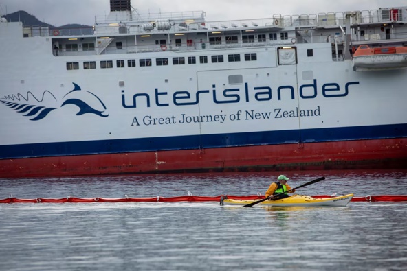A kayaker paddles past the stranded Interislander ferry Aratere in Picton.