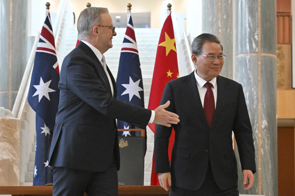 Australia's Prime Minister Anthony Albanese, left, gestures to Chinese Premier Li Qiang after he signed the visitor's book at Parliament House in Canberra, Australia, Monday, June 17, 2024. Li and Albanese and senior ministers of both administrations met at Parliament House on Monday to discuss thorny issues, including lingering trade barriers, conflict between their militaries in international waters and China's desire to invest in critical minerals. (Mick Tsikas/Pool Photo via AP)