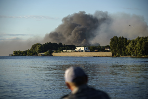 A fisherman watches smoke rise after Russian forces launched a missile attack on a military unit in the Vyshhorod district on the outskirts of Kyiv, Ukraine. Photo / AP