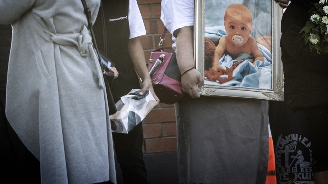 A mourner holds a photo of 10-month-old Mustafa Ali at his funeral in Te Kūiti last month. Photo / Mike Scott