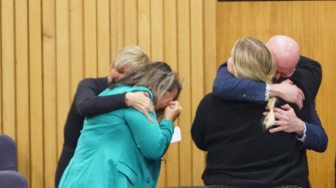 The victim's mother Paula Palmer (green jacket) is comforted by family support person Tracy Manning, as 'whistleblower' Martin Byrne hugs a supporter after William Sullivan was sent to prison in the Nelson District Court. Photo / Tracy Neal