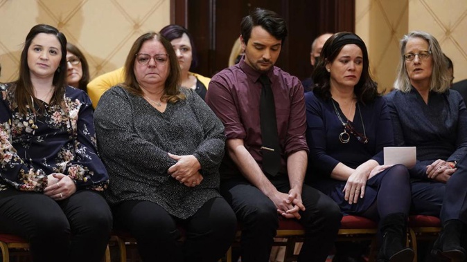 Families of the victims of the Newtown shooting and attorneys listen during a news conference. Photo / AP