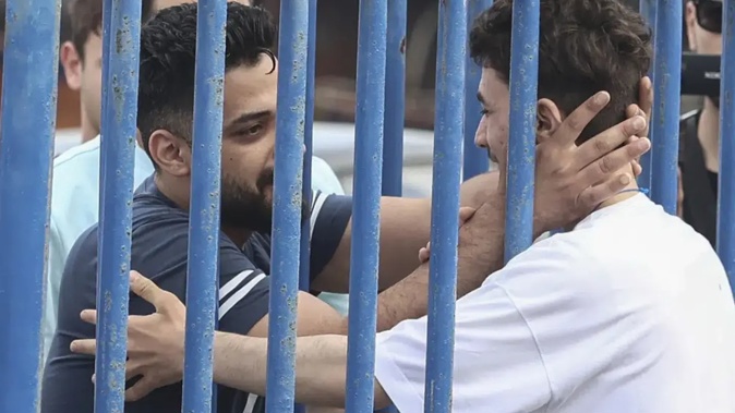 Syrian survivor Fedi, 18, right, one of 104 people who were rescued from the Aegean Sea after their fishing boat crammed with migrants sank, reacts as he reunites with his brother Mohammad, who came from Italy to meet him. Photo / AP