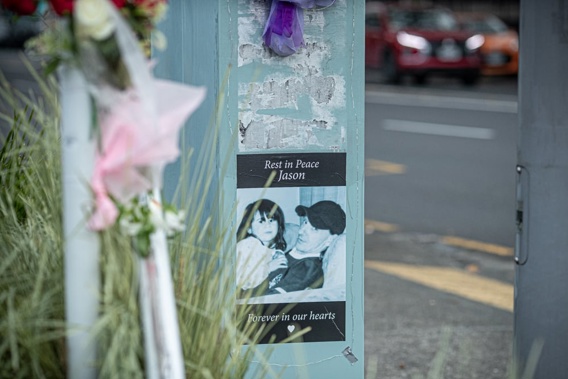 Floral tributes and posters laid at the scene on New North Rd where Jason McEwen was killed while walking his dog last week. Photo / Dean Purcell